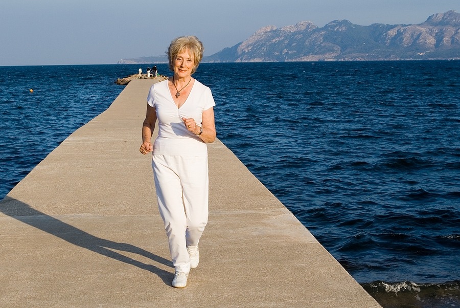 fit healthy attractive senior woman jogging outdoors on summer vacation